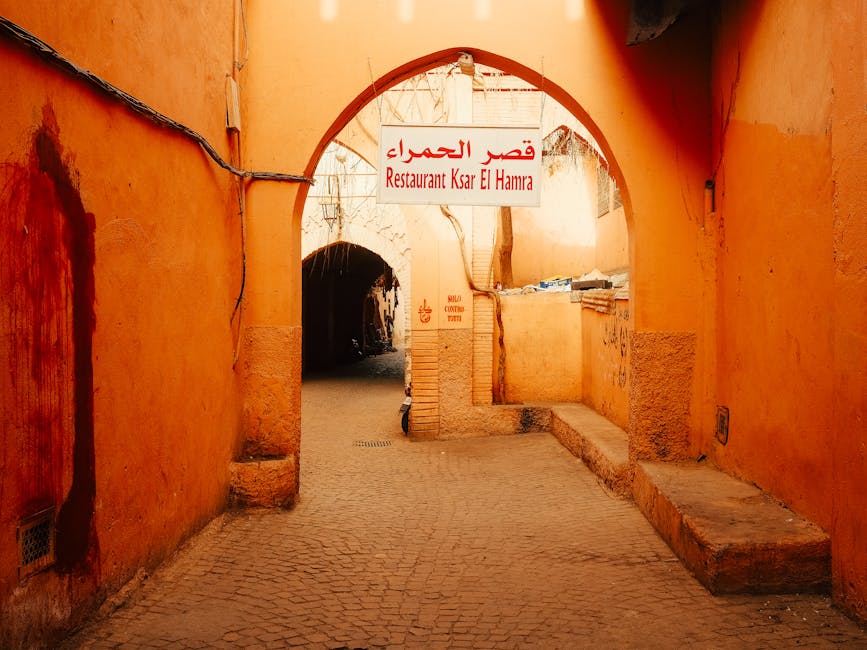 Explore a vibrant alleyway in Marrakesh featuring a traditional Moroccan archway and local restaurant sign.