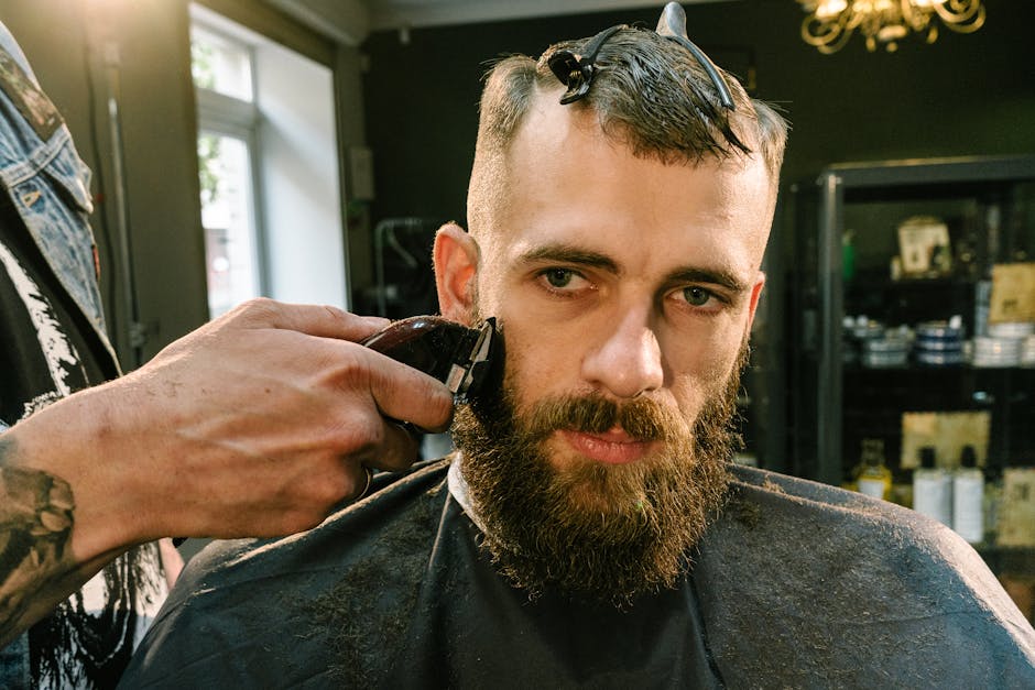 Close-up of a barber trimming a bearded man’s facial hair in a stylish barber shop.