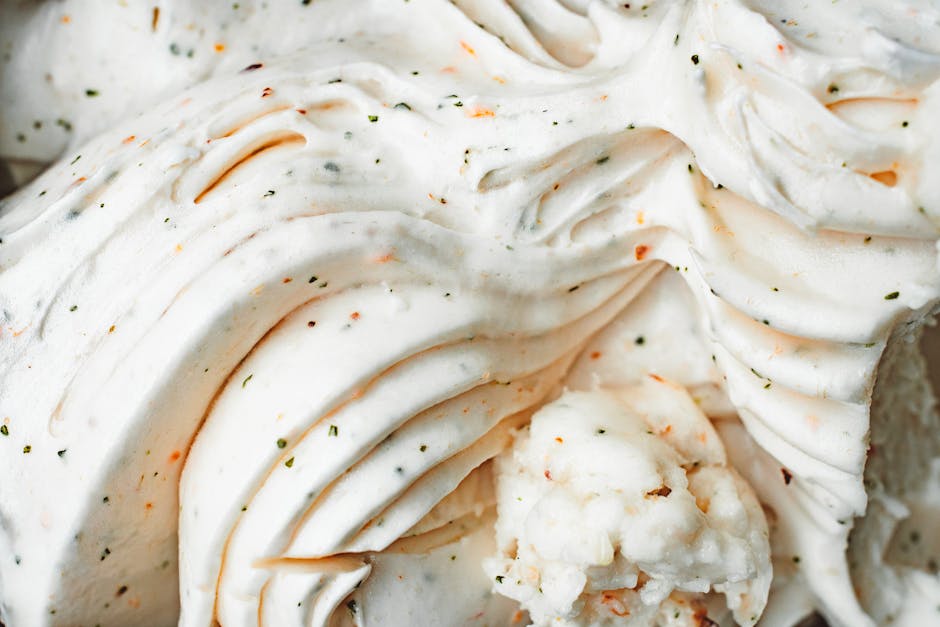 Delicious creamy vanilla ice cream with textured swirls and flecks, captured in a close-up view.