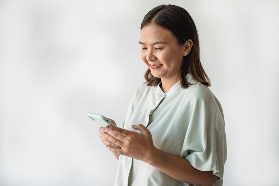Portrait of a smiling woman using her smartphone indoors, creating a joyful interaction.