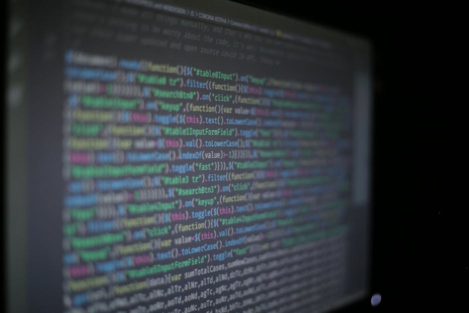 Close-up of colorful programming code on a blurred computer monitor.