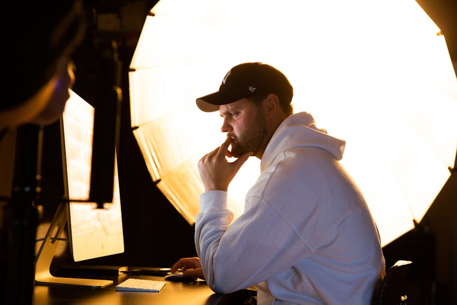 Contemplative man working on computer with professional studio lighting setup