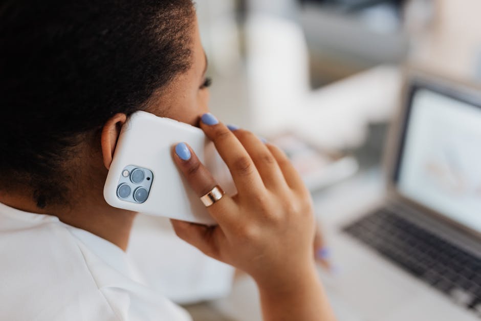 Close-up of a person using a smartphone while working indoors, showcasing technology and connection.