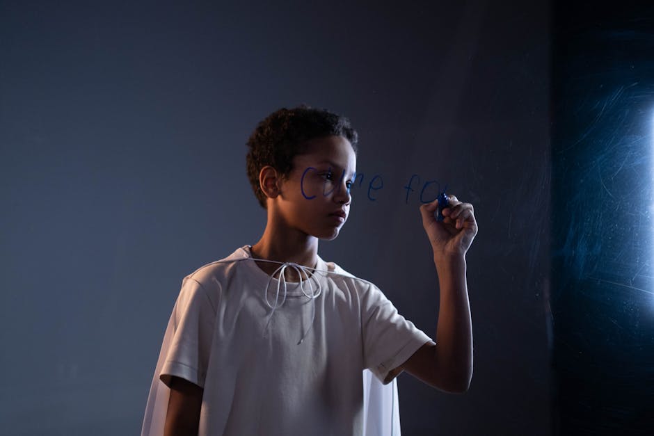 A child in a white cape writes on a glass panel, symbolizing hope and creativity.