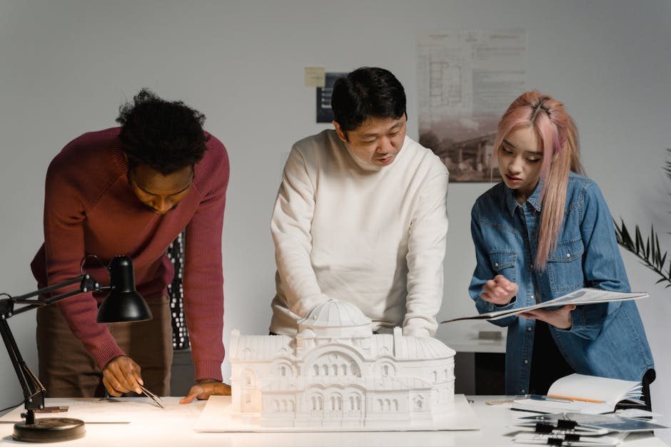 Architects discussing and planning a scale model in a modern office setting.
