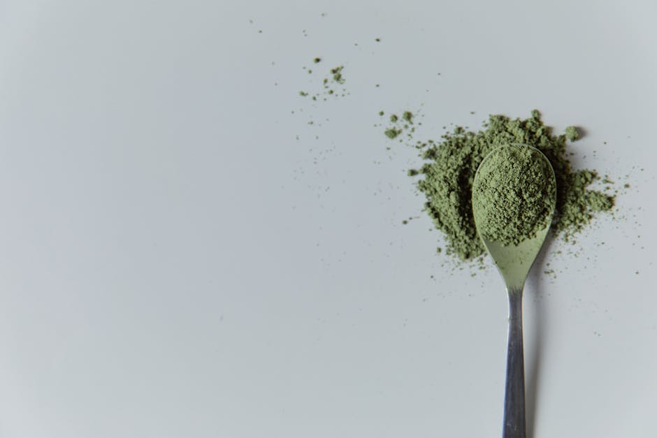 High-quality matcha powder on a spoon in a minimalist studio setting, ideal for culinary and wellness themes.
