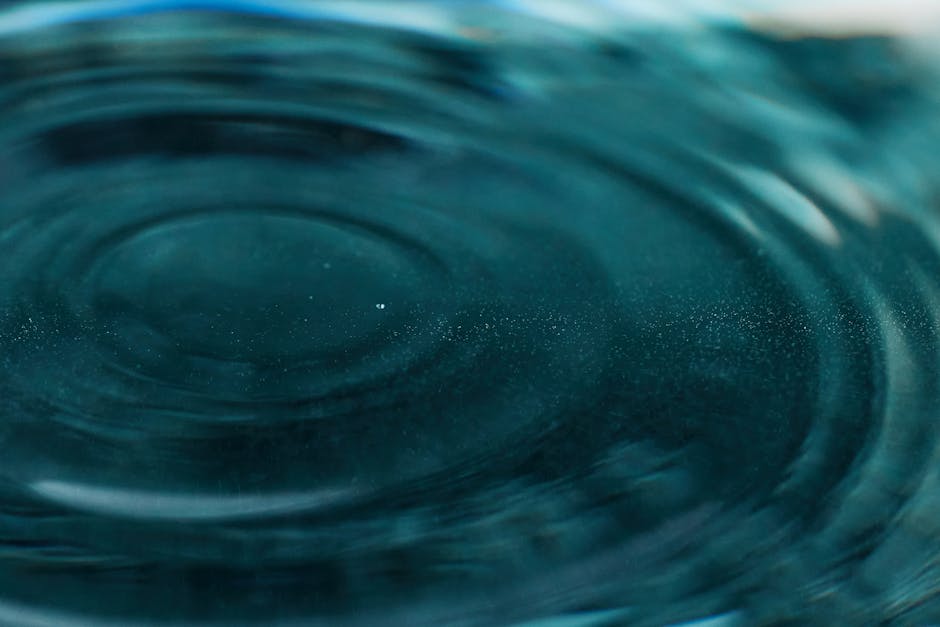 Abstract close-up of water ripples forming mesmerizing patterns with teal hues.