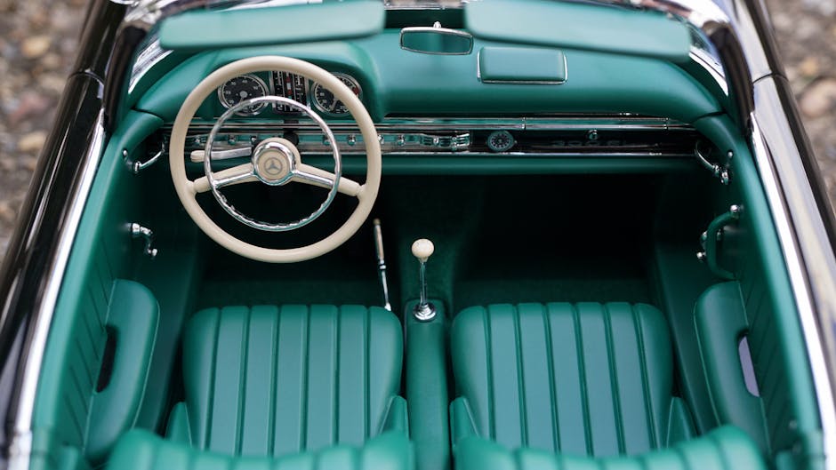 Vintage Mercedes car interior featuring green seats and dashboard, highlighting classic automotive design.