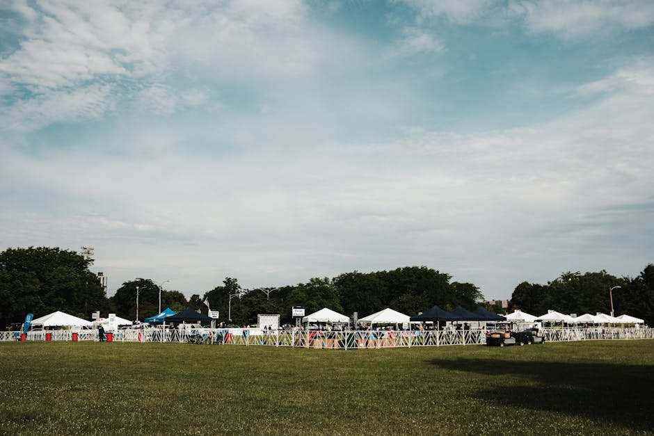 An outdoor event setup in a Chicago park featuring tents, grass, and a sunny summer day.