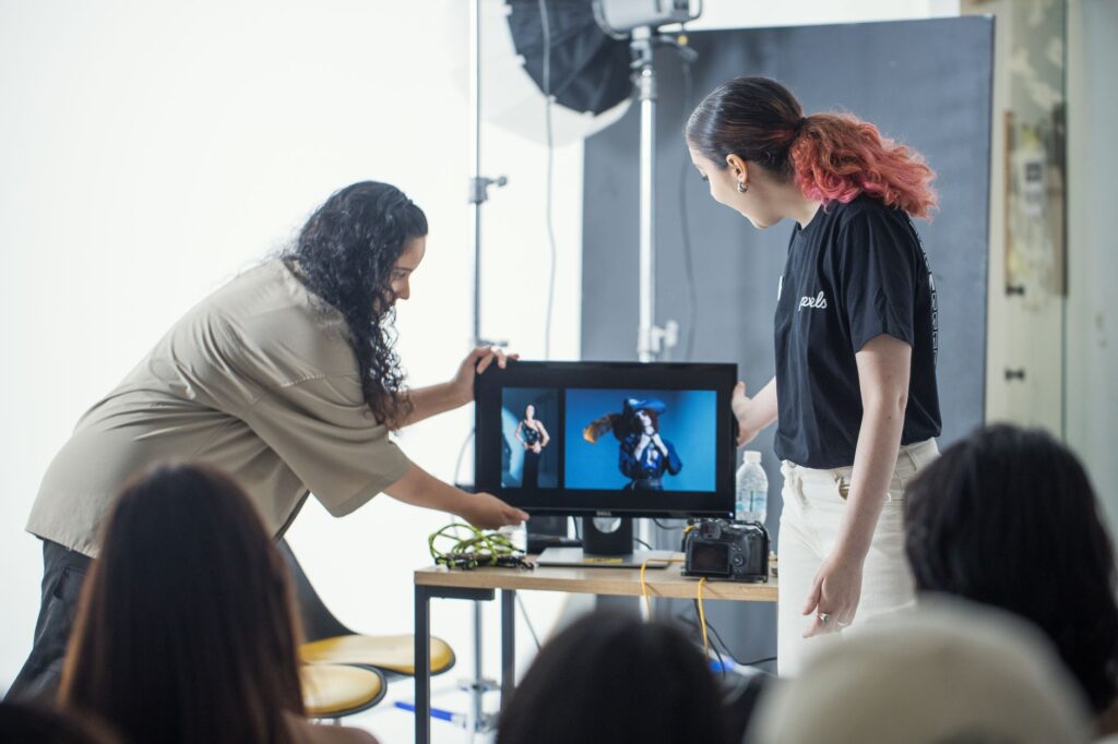 Two developers at a shared monitor reviewing log output during a conflict diagnostic session
