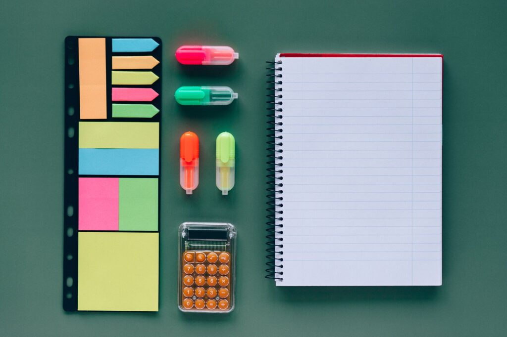 Notebook with handwritten triage notes and color-coded sticky markers covering scope, environments, and conflicts