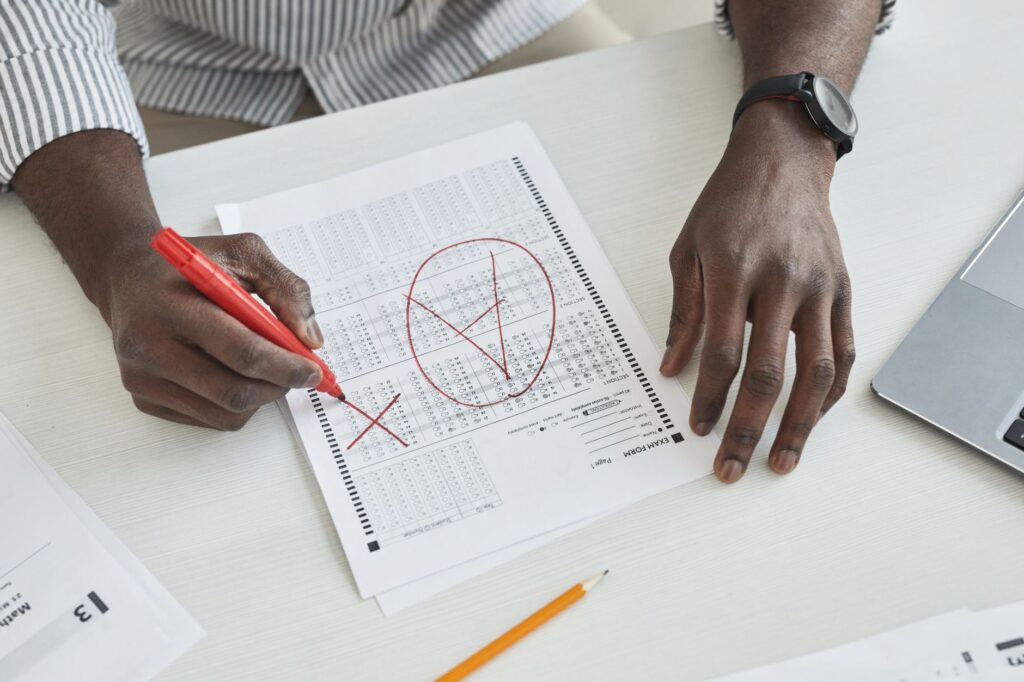 QA checklist sheet stacked on top of a printed plugin manifest with red pen corrections