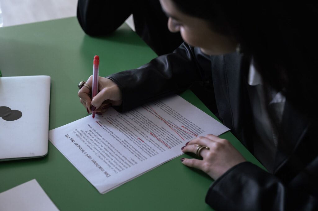 Side-by-side vendor proposals open on a desk with red flags marked by hand on the pages